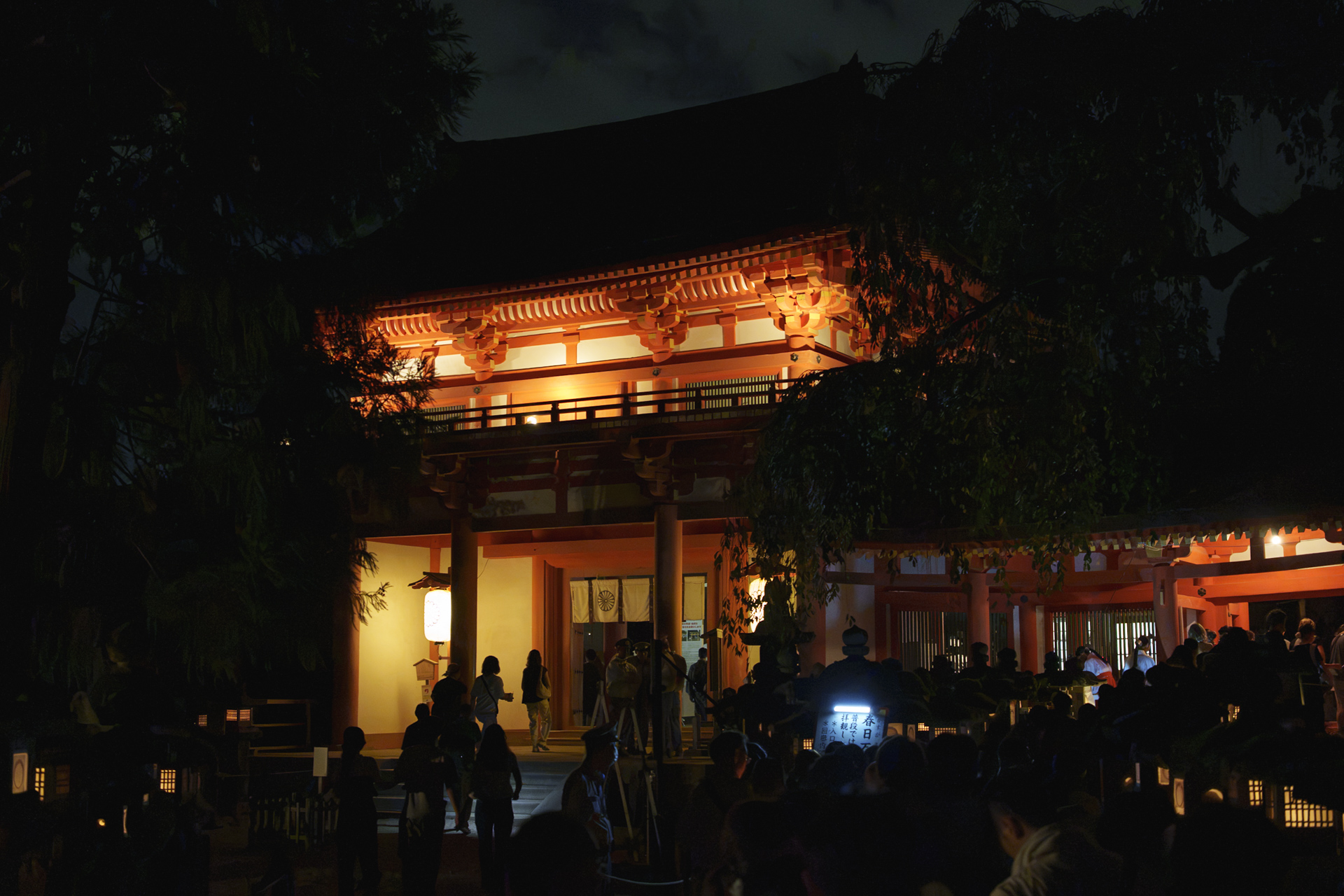 夜の春日大社の門と参拝する人々