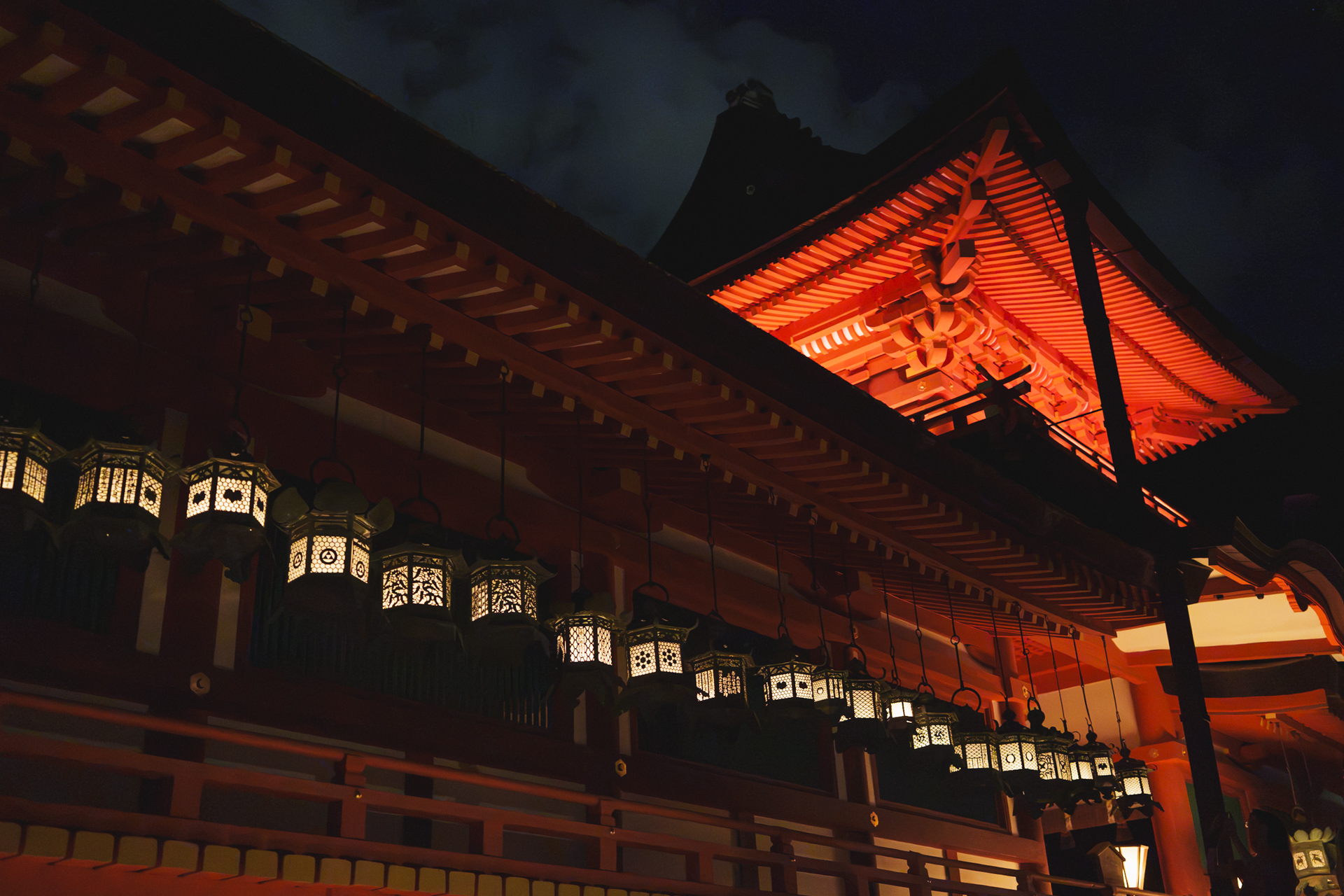 朱色の建物と回廊に並ぶ釣燈籠